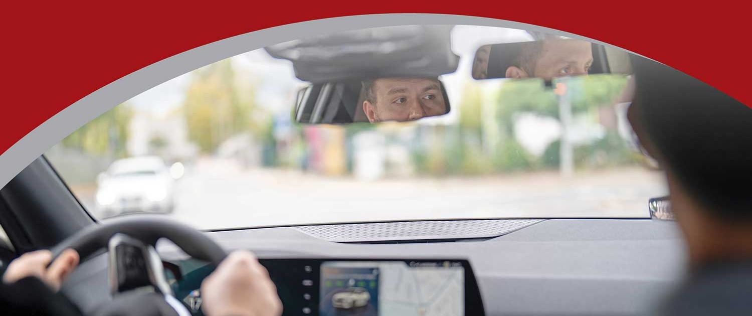 Fahrstunde bei Martins Fahrschule Düsseldorf – Fahrlehrer beobachtet im Rückspiegel