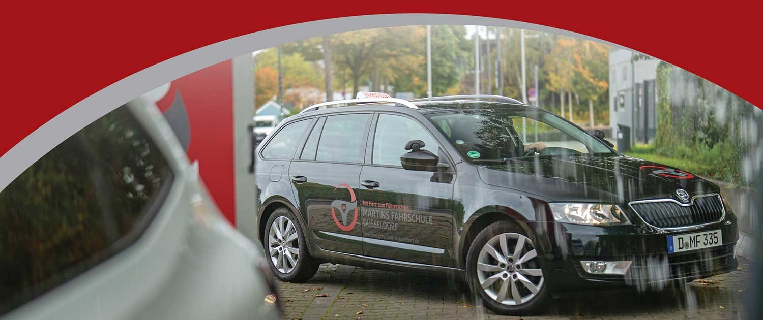 Martins Fahrschule Düsseldorf – Fahrschulauto bei Regenfahrt, professionell bei jedem Wetter